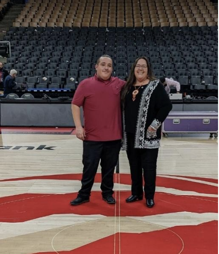 Heyo:te’dok – Fran, and Haya’no:we’ – Jacob Davis are from Six Nations of the Grand River territory, Cayuga nation and Wolf clan standing in an auditorium.